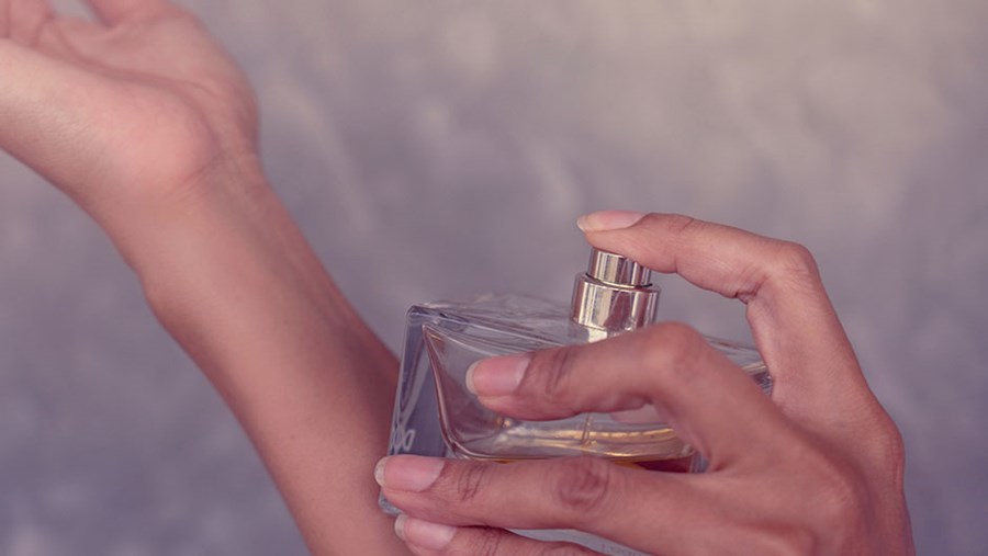 Egy nő parfümöt fúj a csuklójára