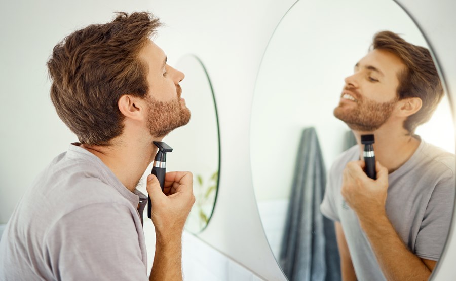 Férfi áll a tükör előtt és borotválkozik