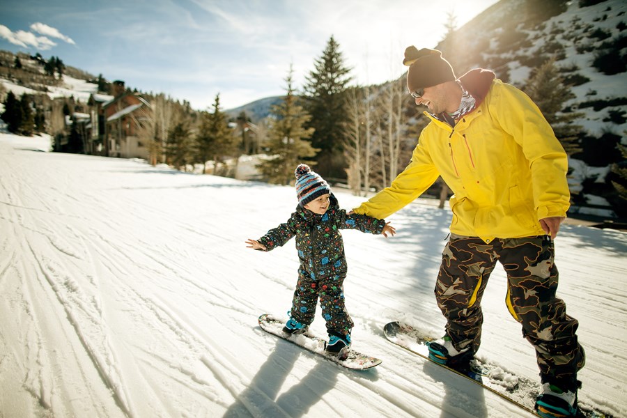 Apuka a kisfiát tanítja snowboardozni